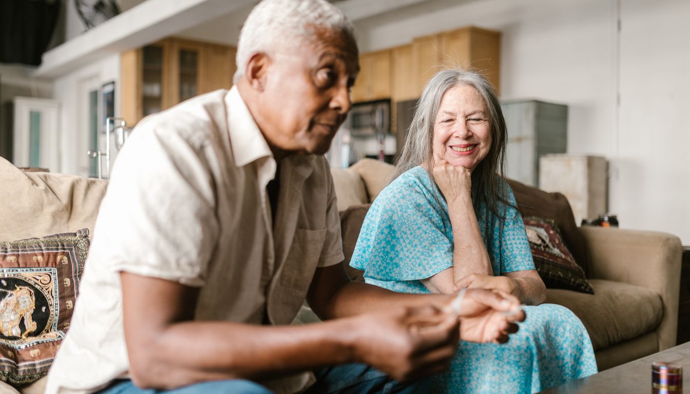 An older couple talking together on their living room sofa